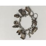 A silver charm bracelet with 12 charms attached. T
