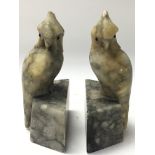 A heavy pair of marbled book ends both with cockat