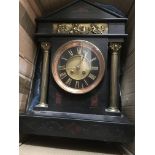 A Black marble mantle clock, the circular dial having Roman numerals, flanked by Corinthium columns