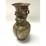 A Chinese brass vase decorated with a raised drago