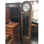 A 1930s oak long case clock with a round dial chro