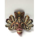 A small painted wooden tribal face mask. The heigh