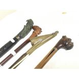 A collection of walking sticks including one carve