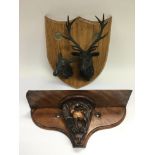 A wooden plaque with attached stag and doe heads p