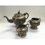 An Indian silver tea set comprising teapot, cream jug and a sugar basin. Approx 736g.