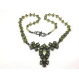 A silver and green peridot necklace.