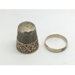 An unmarked gold ring and a thimble (2).