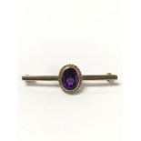 A 9 carat gold bar brooch set with an amethyst sto