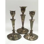 Three white metal candlesticks comprising a pair p