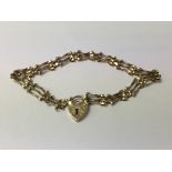 A late 20th century 9ct gold gate link heart padlo