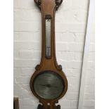 A Negretti and Zambia oak barometer with applied thermometer and silver dial . 108 cm .