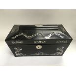 An ebony tea caddy inlaid with mother of pearl.