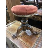 A Victorian walnut piano stool with circular seat