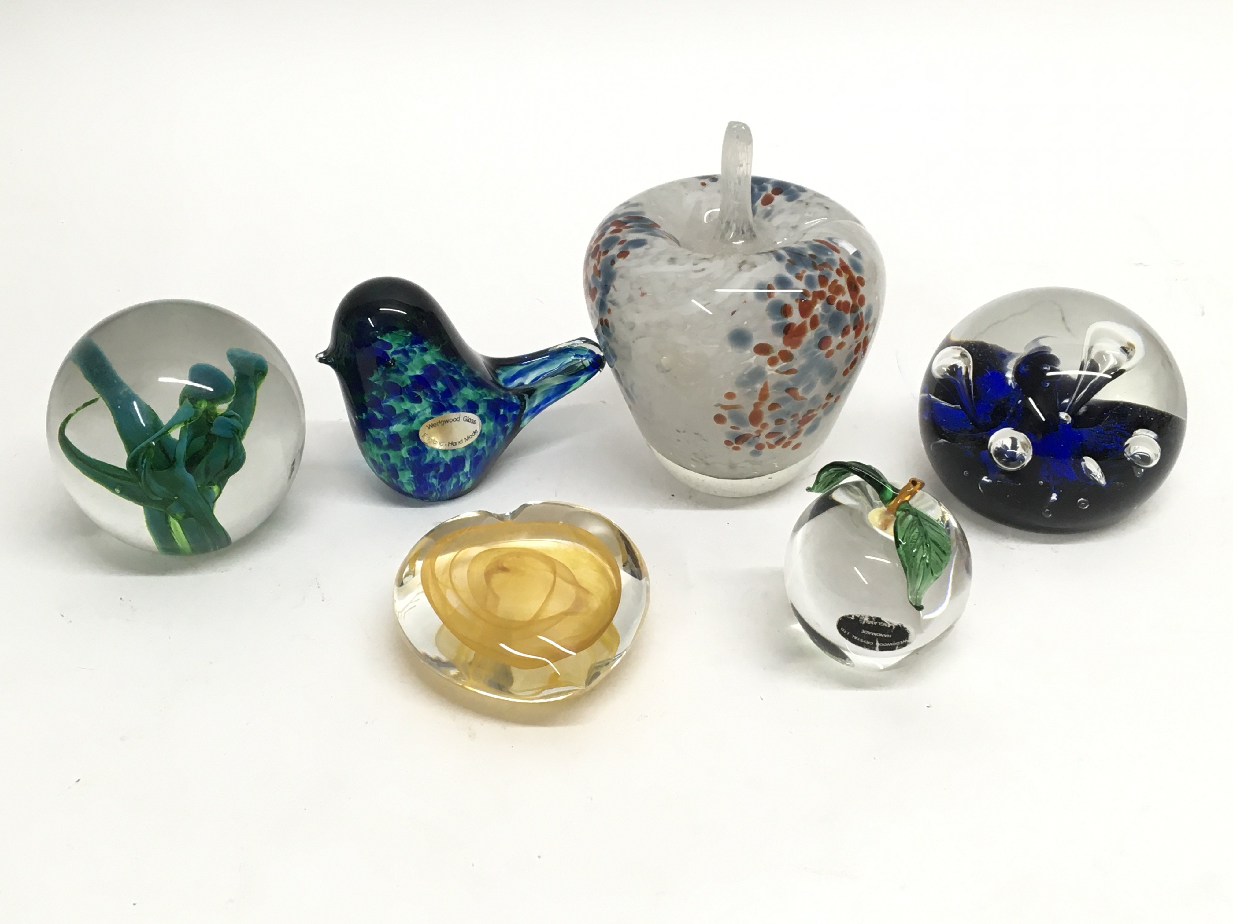 A collection of six decorative glass paperweights including Murano, Caithness and Wedgwood