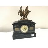 A black slate and marble mantel clock the top surm