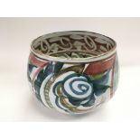 A glazed contemporary bowl decorated in various co