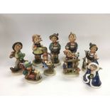 Nine Goebel figures of children.