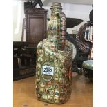 An old jug bottle decorated completely with cigar
