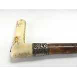 An Edwardian shibayama style walking stick with ivory handle and silver collar.