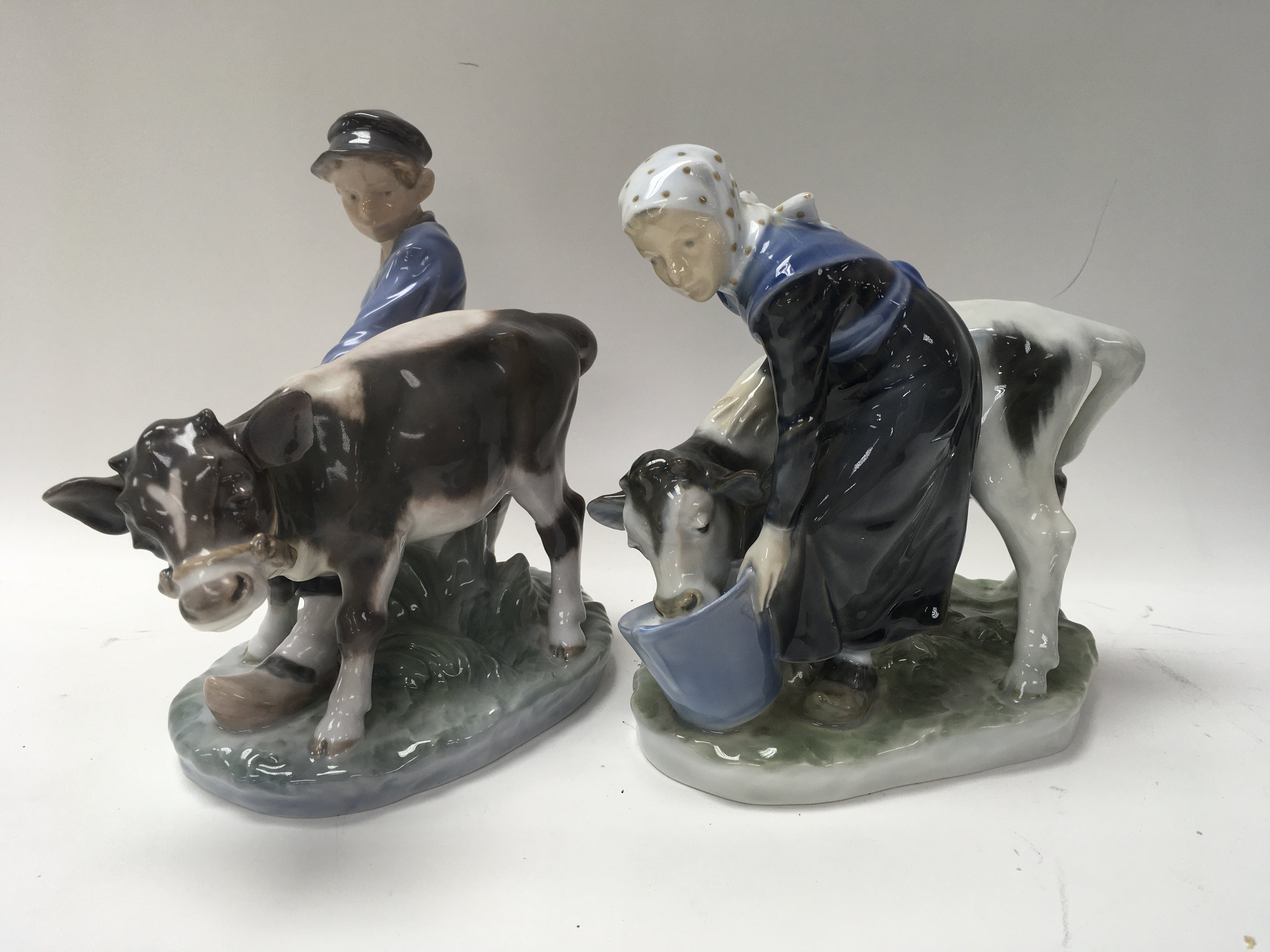 Two Royal Copenhagen figures with cows .