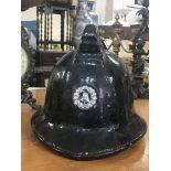 A black leather Fireman's helmet with helmet badge