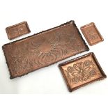Four copper trays of various sizes, three with matching designs