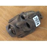 A small African carved mask with protruding tongue