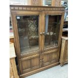 An Ercol 4 door glazed front bookcase. 137.5 x 101