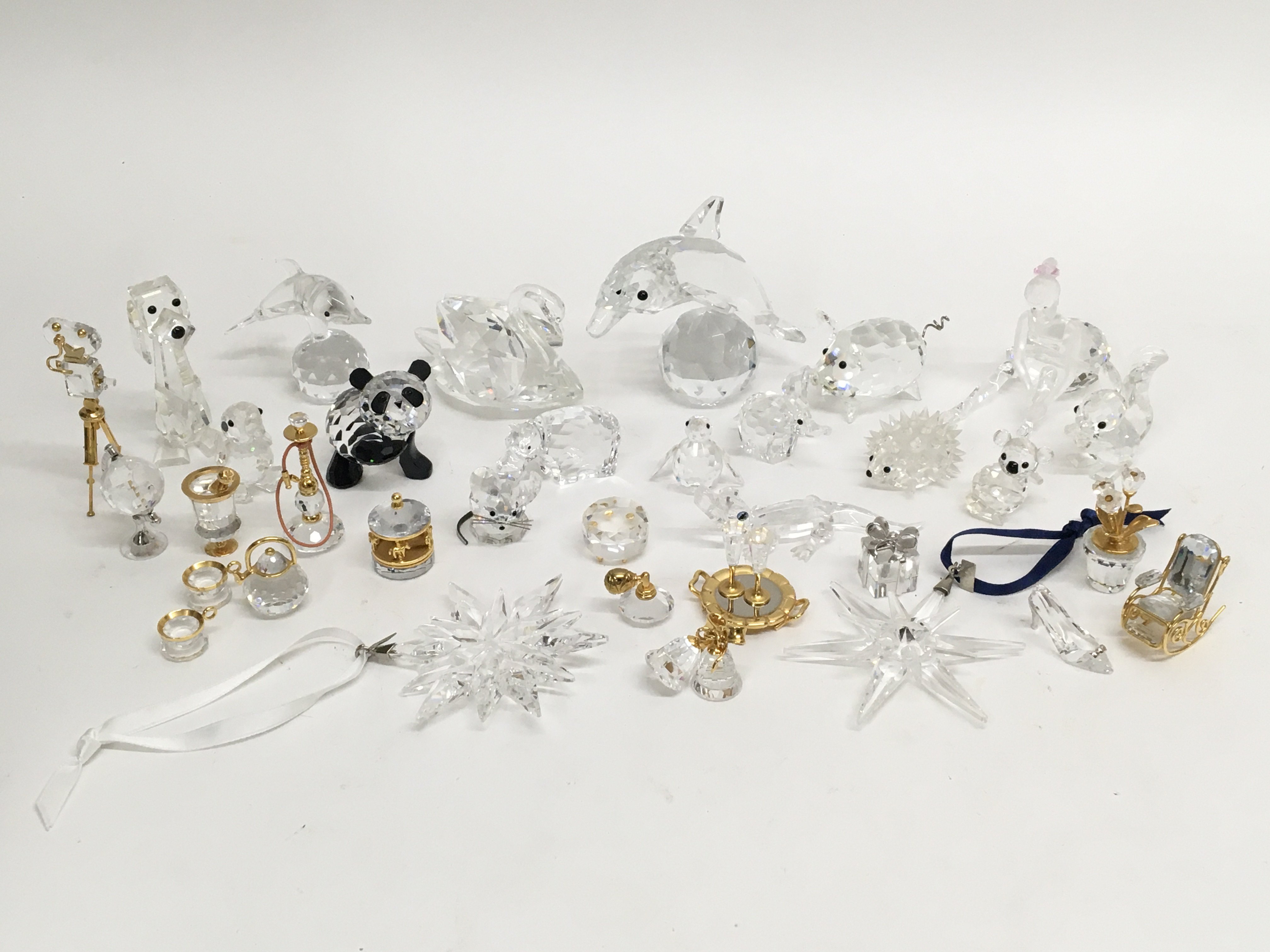 A collection of Swarovski glass ornaments including two hanging Christmas ornaments and conforming