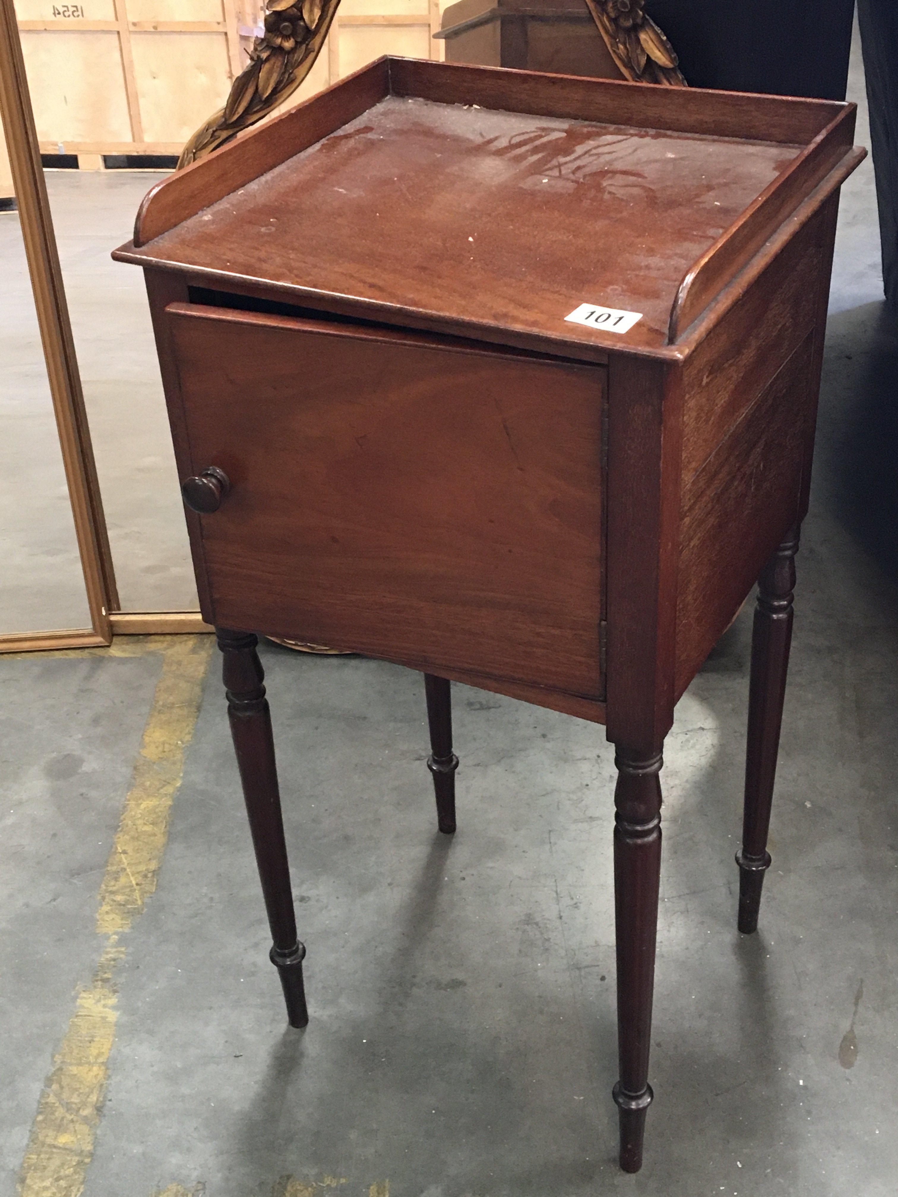 A late George III mahogany pot cupboard with turned legs.