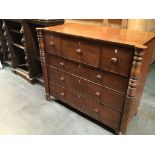 An Early Victorian chest of drawers the top with a hat box and deep drawers flanked by turned