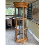 A tall hexagonal teak framed upright display cabin