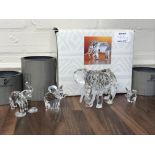 Four Swarovski elephant figures with boxes. One is