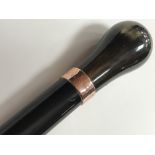 An ebonized walking stick with horn handle and 9ct