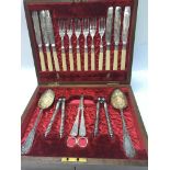 A cased cutlery set with ornate detailing in a woo