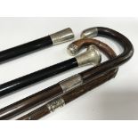 Four walking sticks with silver collars and handle