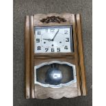 A cased walnut hanging wall clock with swinging pe