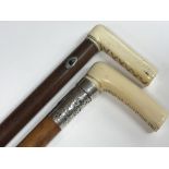 Two walking sticks with ivory handles, one with si