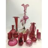 A collection of cranberry glass items including a