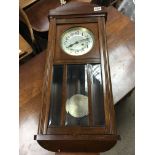 A 1950s wall clock with brass pendulum. Height is