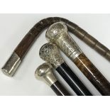 A collection of four walking sticks with silver to