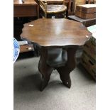 A solid oak occasional table with a shaped top the