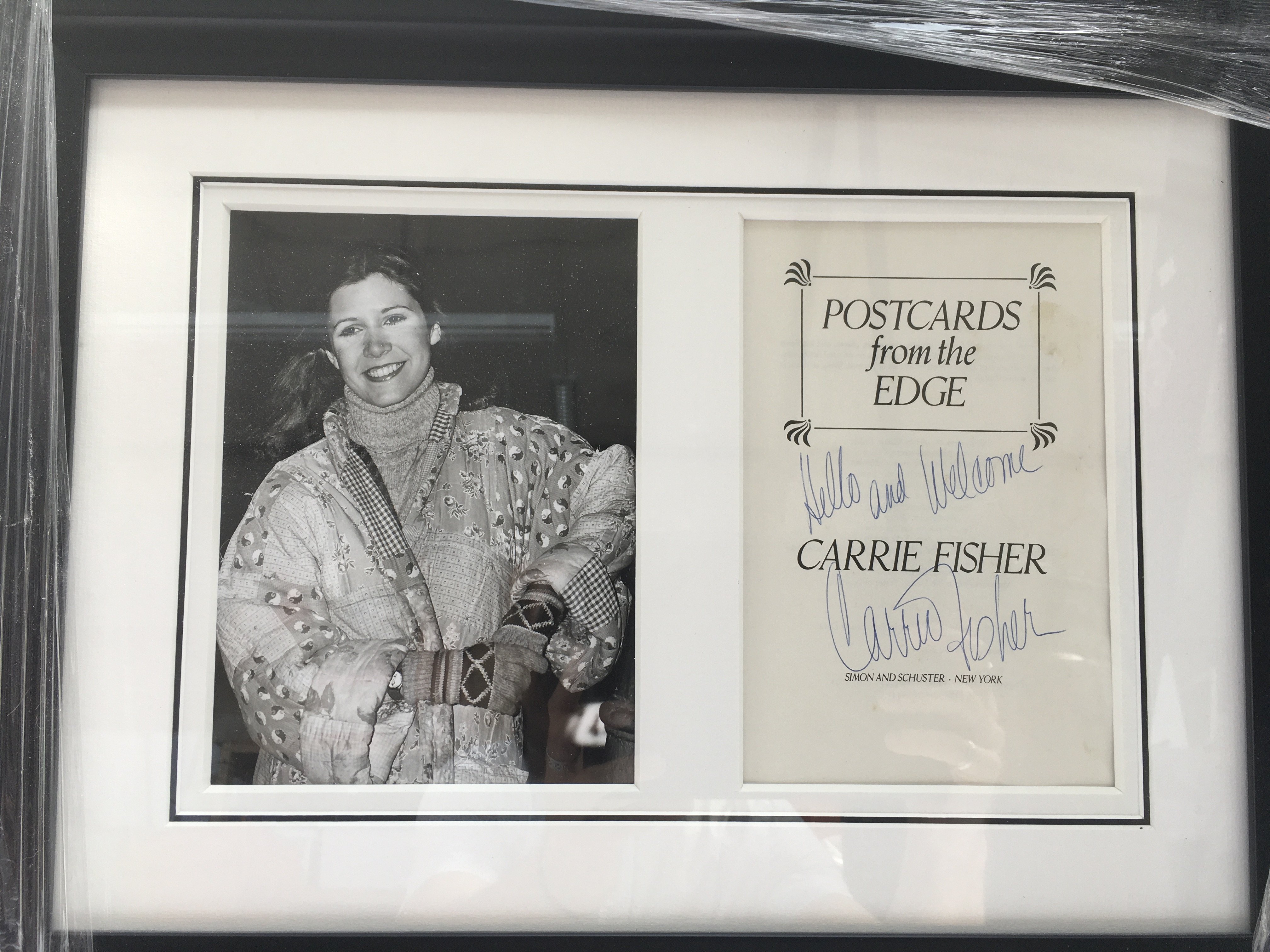 A framed and glazed Carrie Fisher signed book page