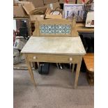 A small pine wash stand with marble top and tile back.