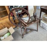 An antique oak framed spinning wheel in working order.