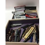 A box containing a quantity of vintage pens, some