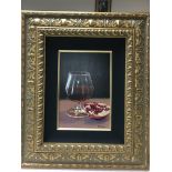 A framed still life study signed by the artist E Denis. Depicting a half full brandy glass, and a