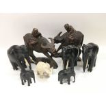 A collection of carved wooden buffalo and elephant