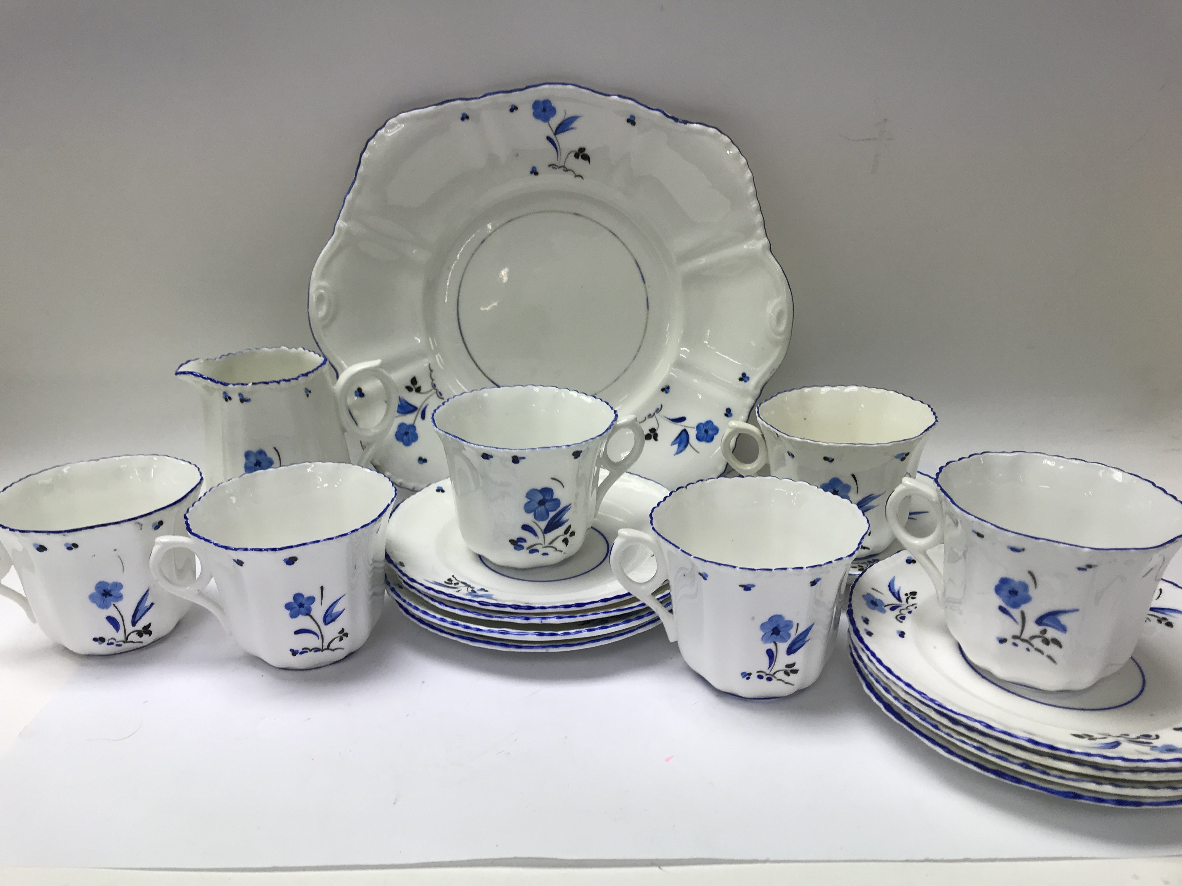 A Edwardian tea set decorated with blue flowers. Including cups saucers sandwich plate .