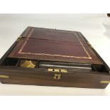 A rosewood and brass sloped writing box with red l